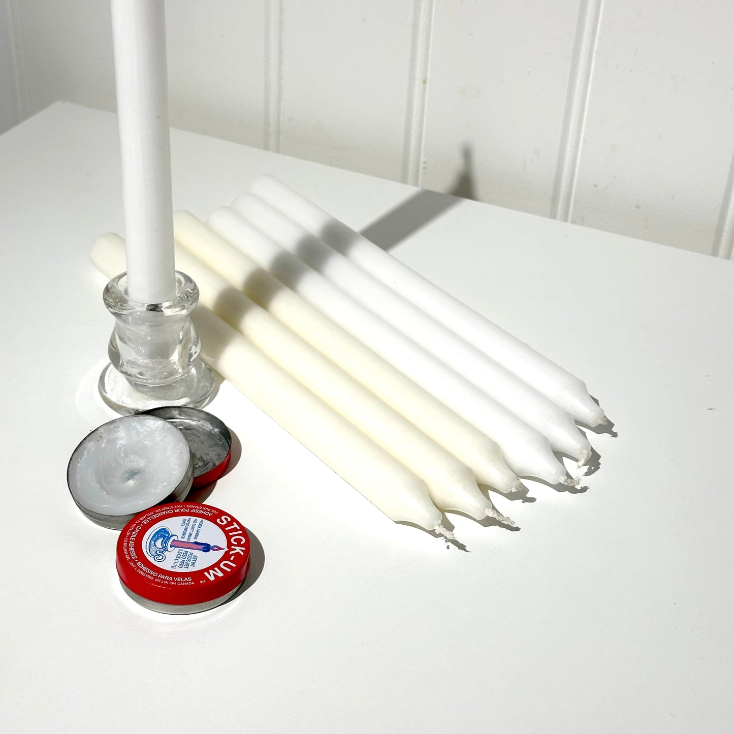 dinner candles can of stickum and glass candle holder white background