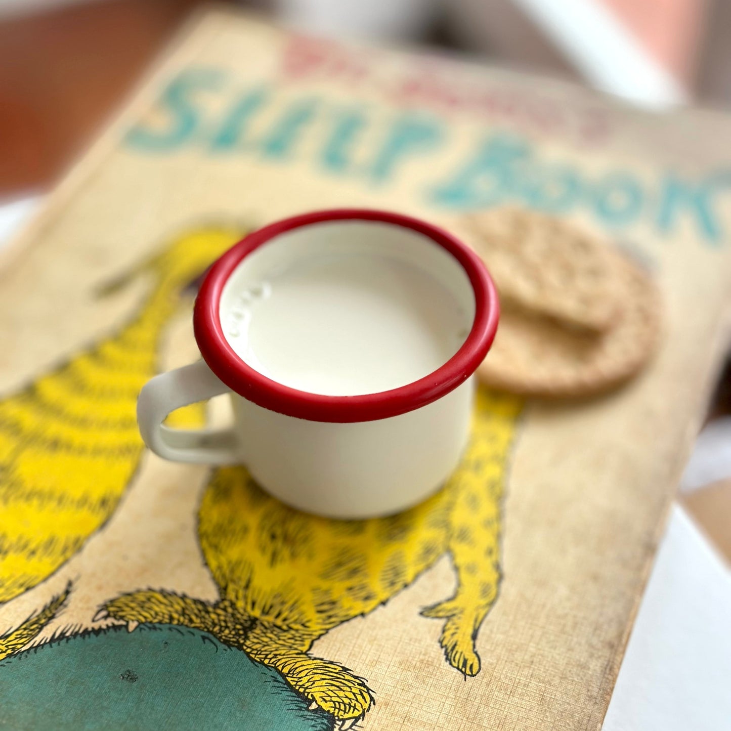 Small white cup with red rim on a children's book Dr Seuss