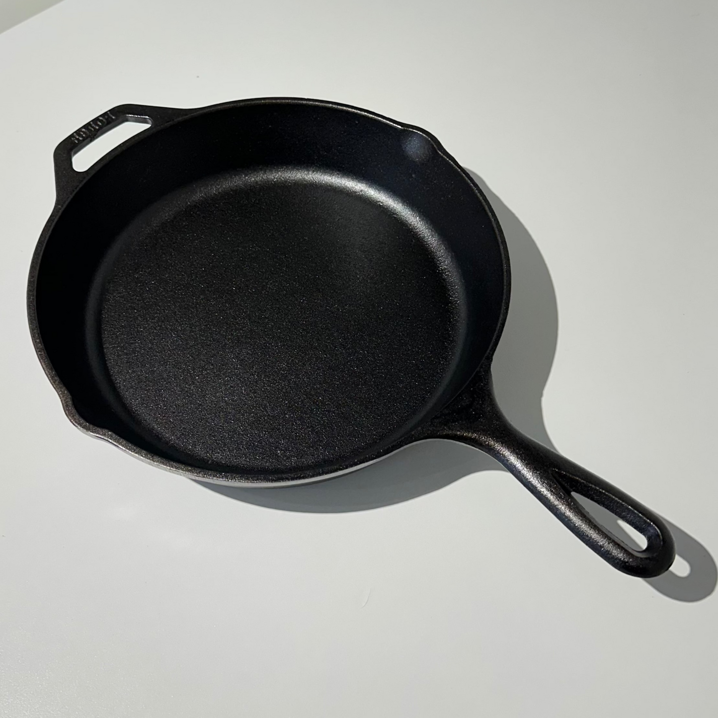 Black cast iron skillet on a white surface