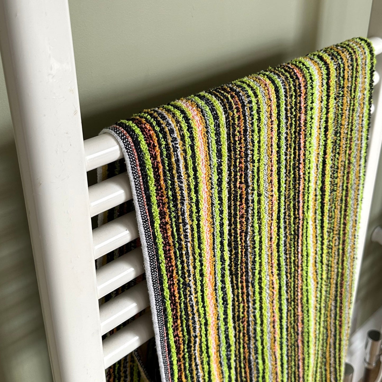 Towel rack with a striped towel neutral background