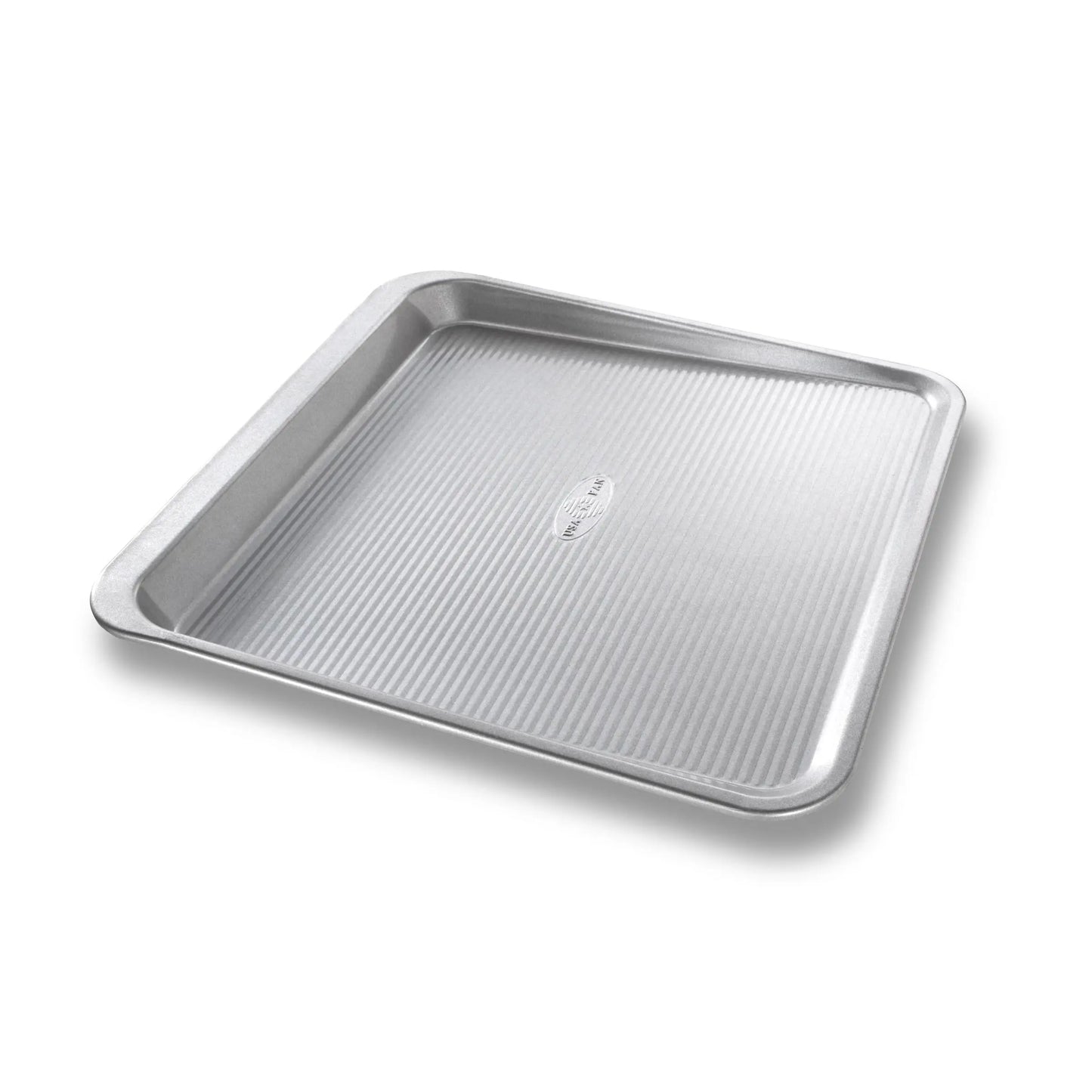 A square stainless steel baking pan with a ribbed textured bottom and raised rim, shown at an angle on a white background.