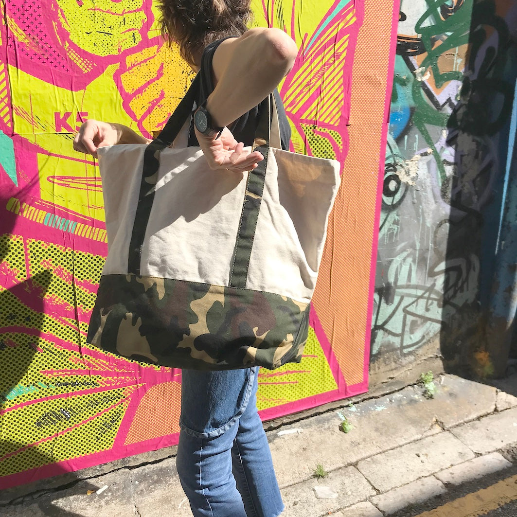 Canvas tote bag with camouflage details worn on shoulder colourful background
