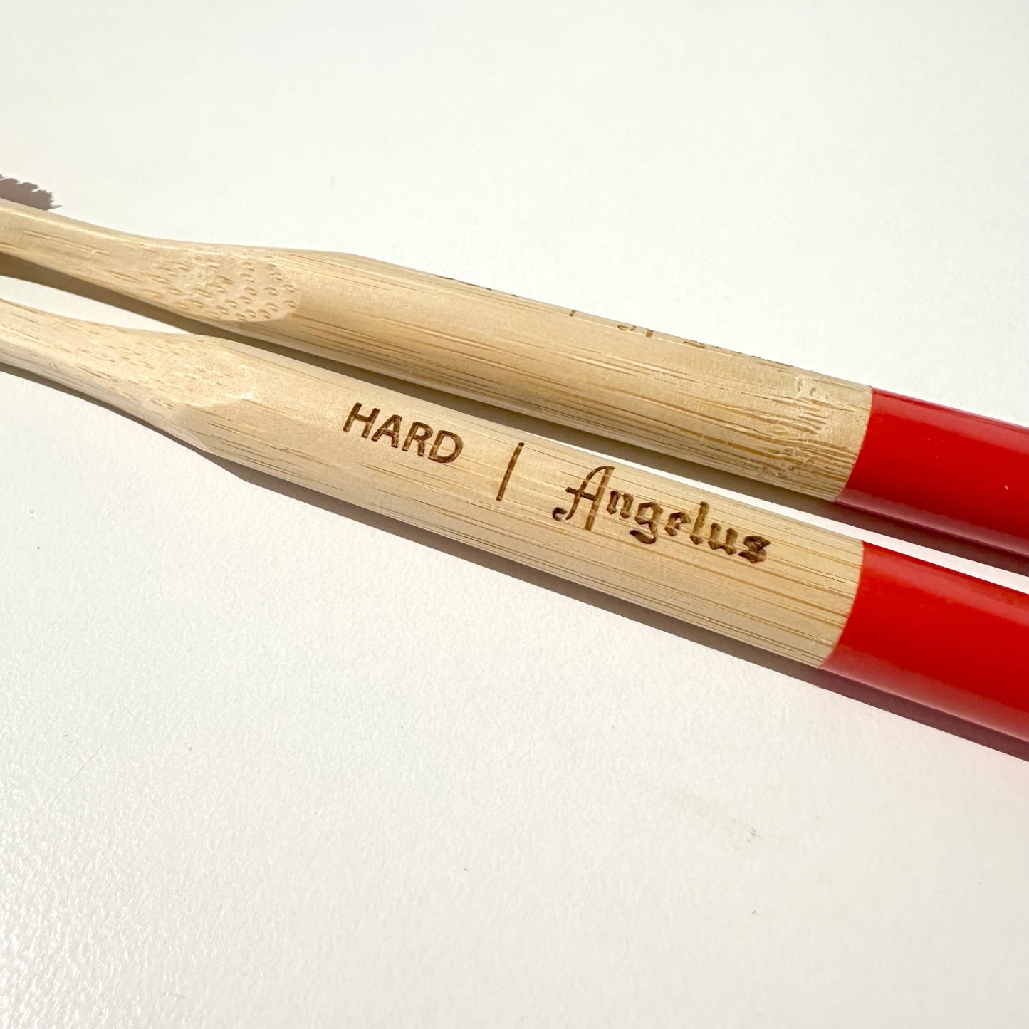 Two detail brushes with wooden handles and red ends, labeled 'Hard' and 'Angelus'.