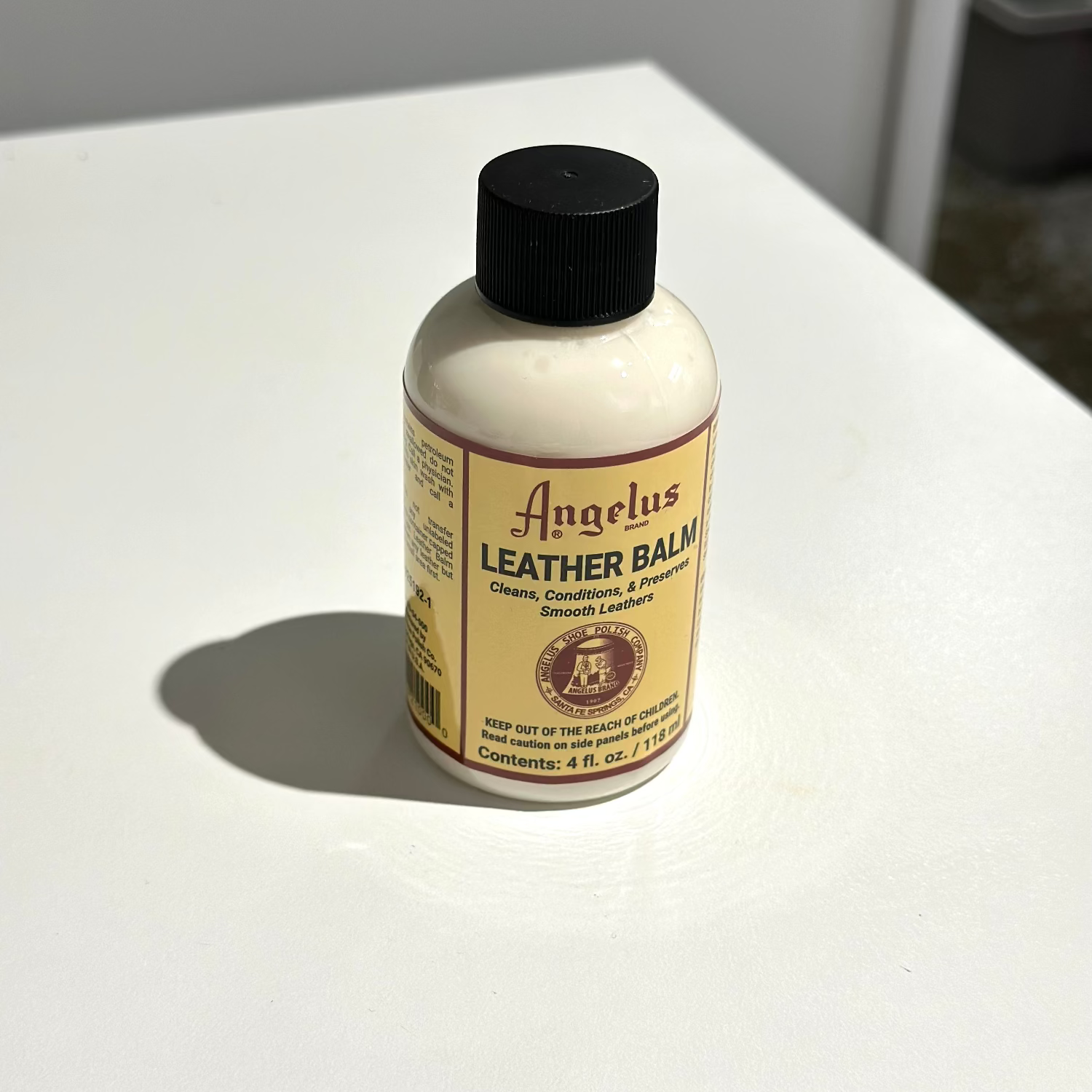 Angelus Leather Balm bottle on a white surface with a neutral background