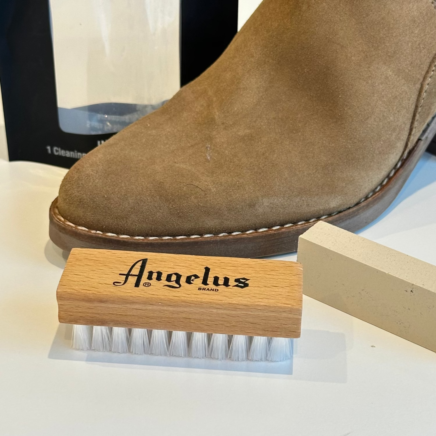 Brown suede boot with Angelus brand brush and block on a white background