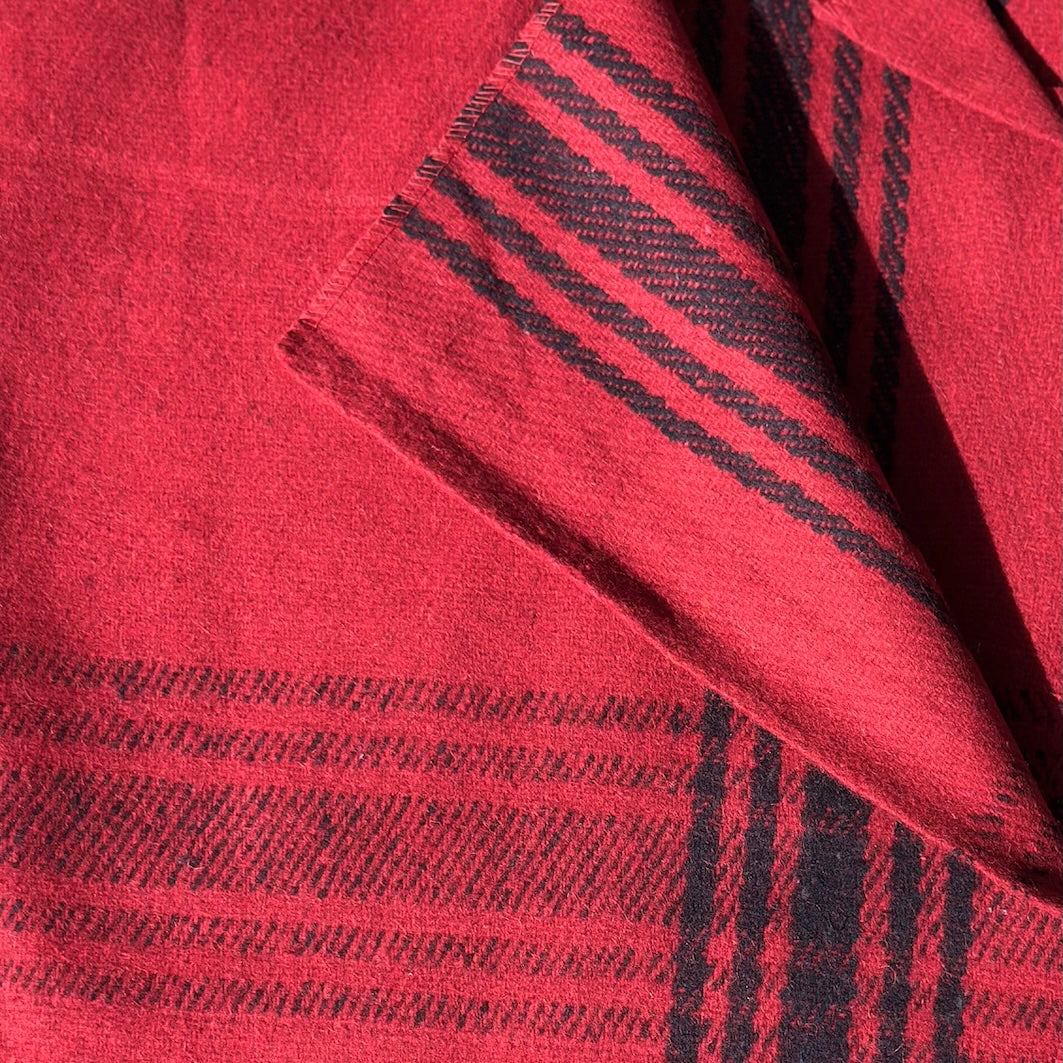 Detail of red wool blanket with a navy blue stripe check weave
