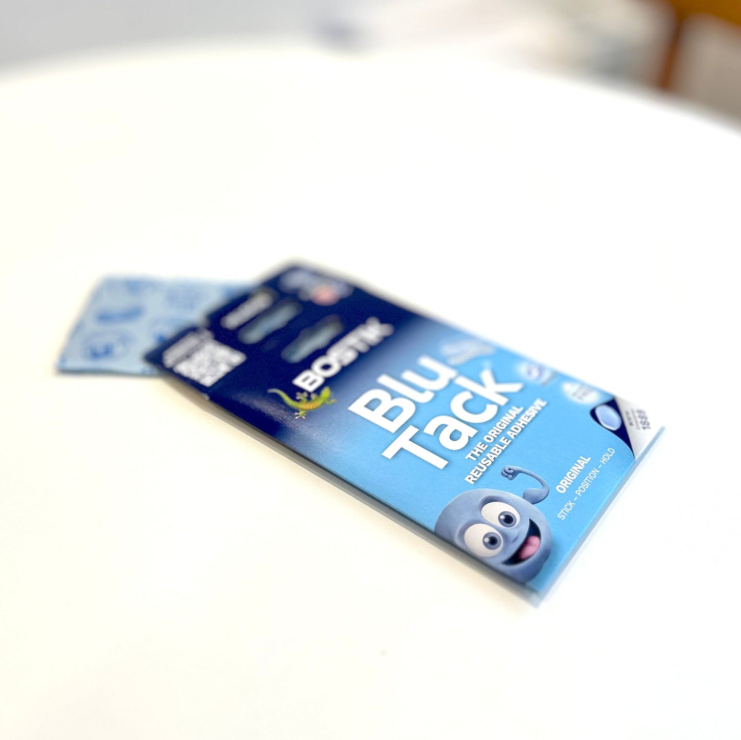Blu Tack packaging on a white surface