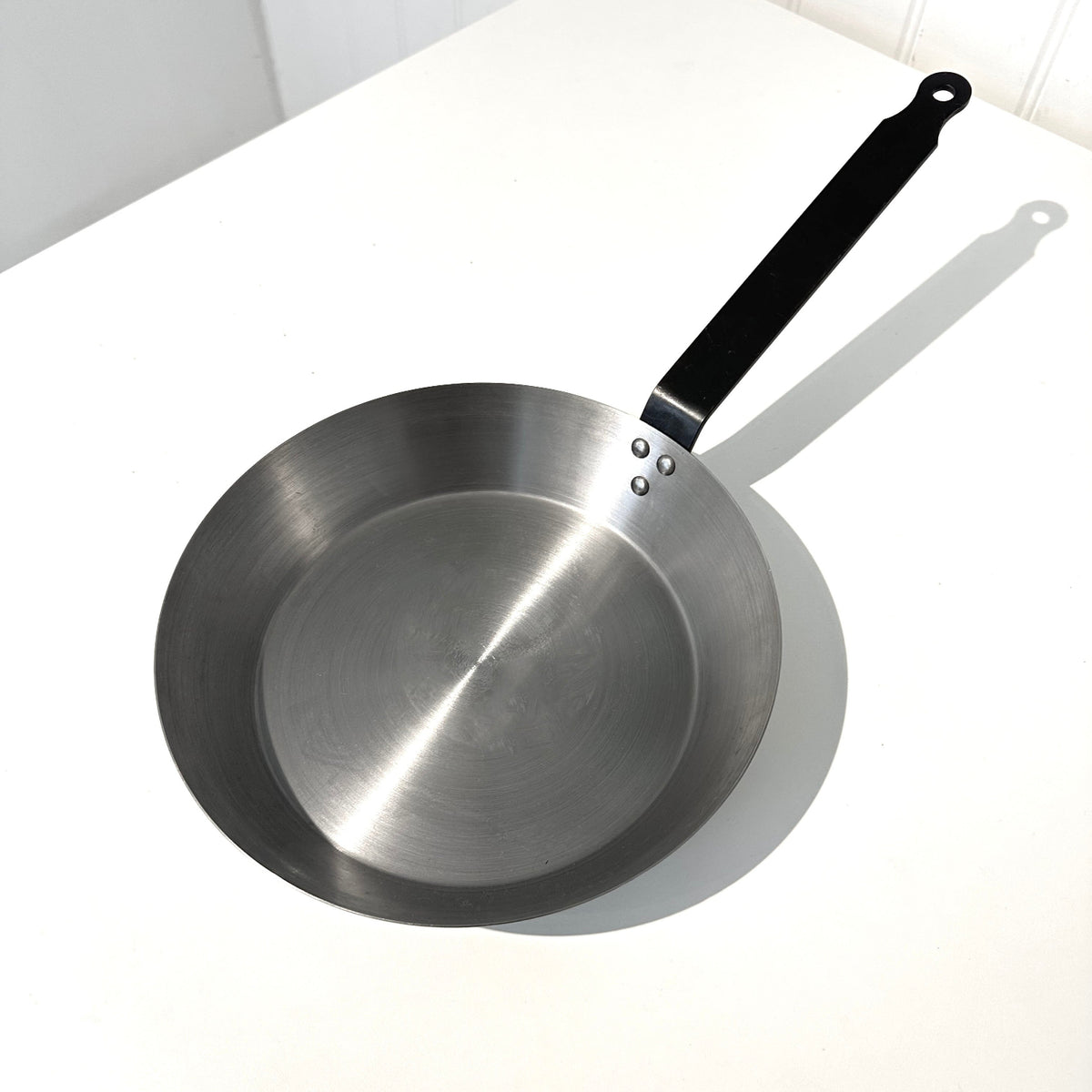 Carbon steel pan 26cm on a white table