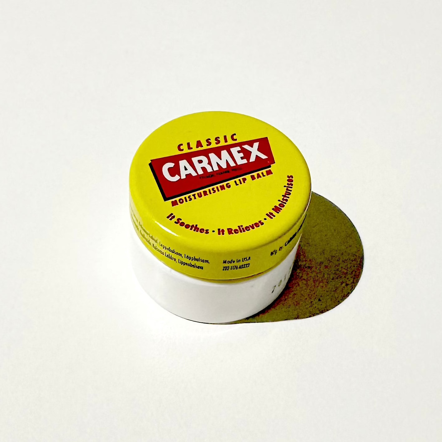 Carmex lip balm container on a white surface