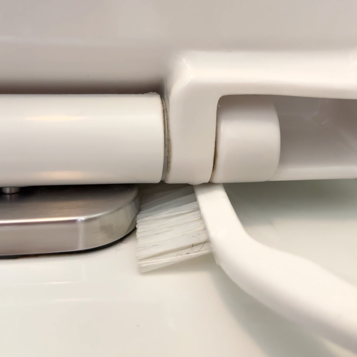 Corner brush cleaning toilet seat hinge