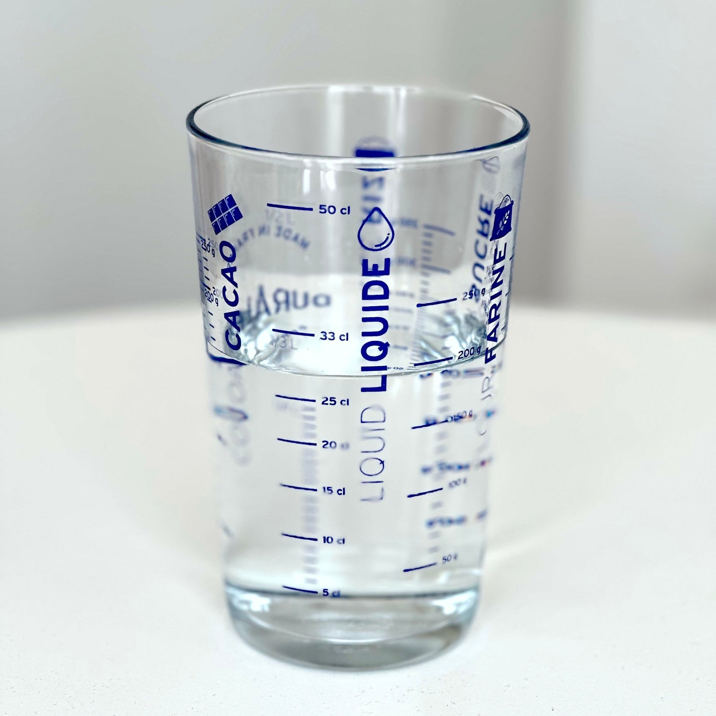 Duralex measuring glass with water white background