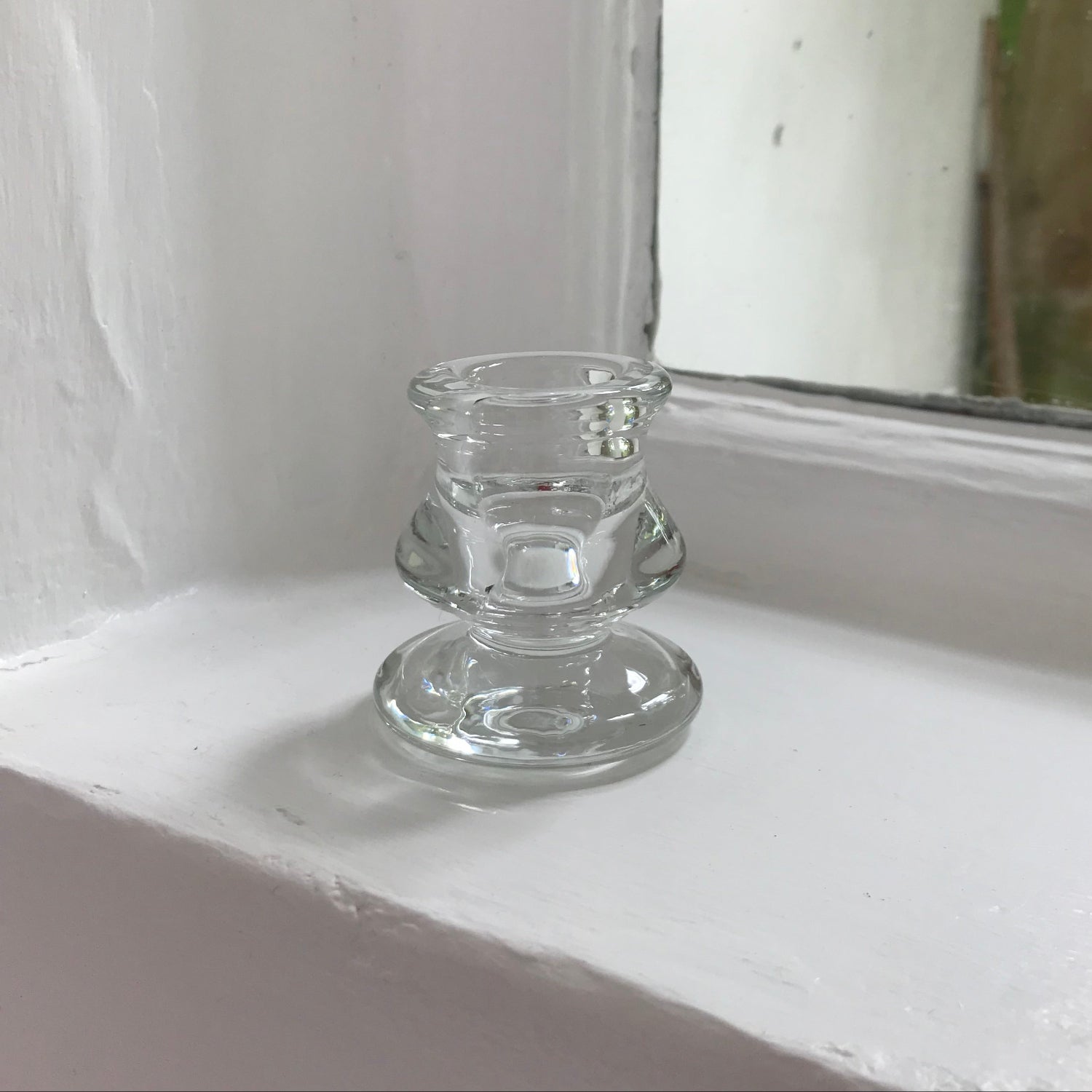 glass candle holder on window sill