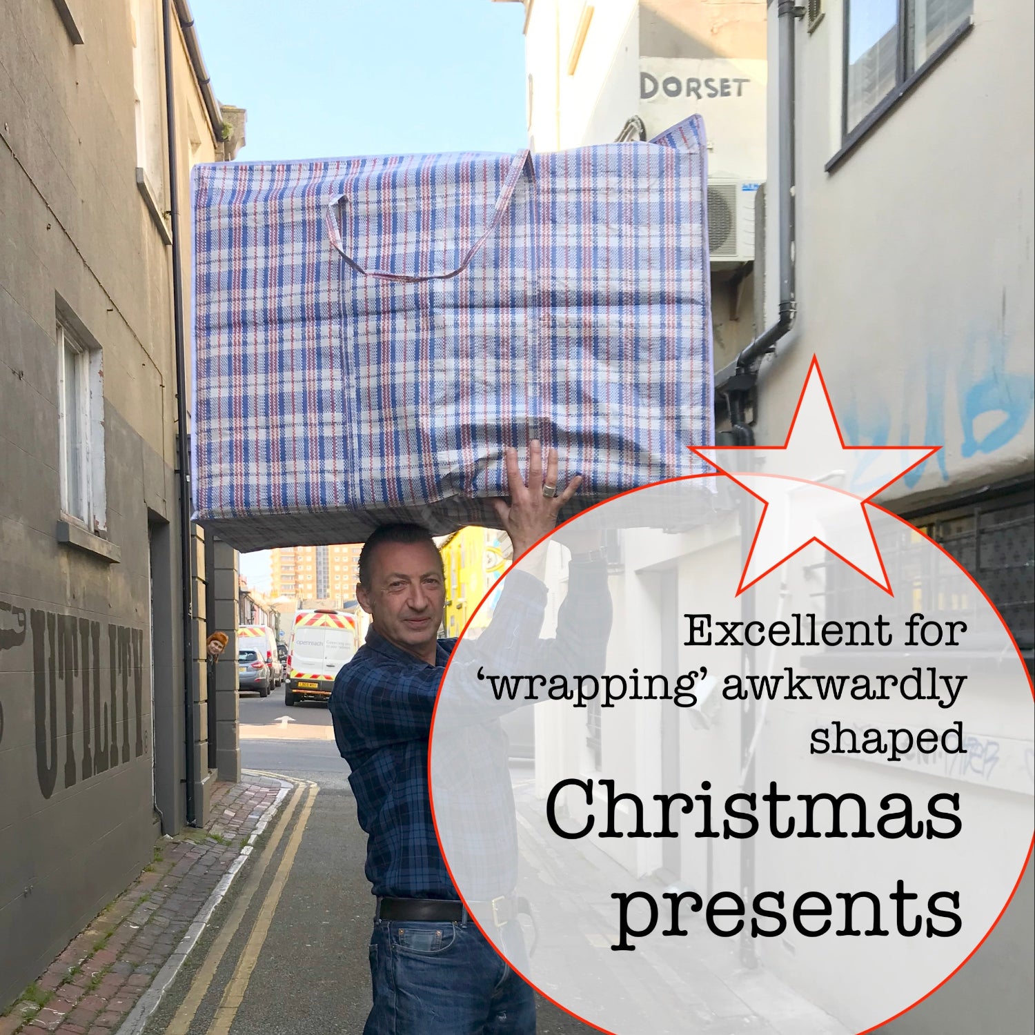 Person holding a large rectangular box above their head on a street.