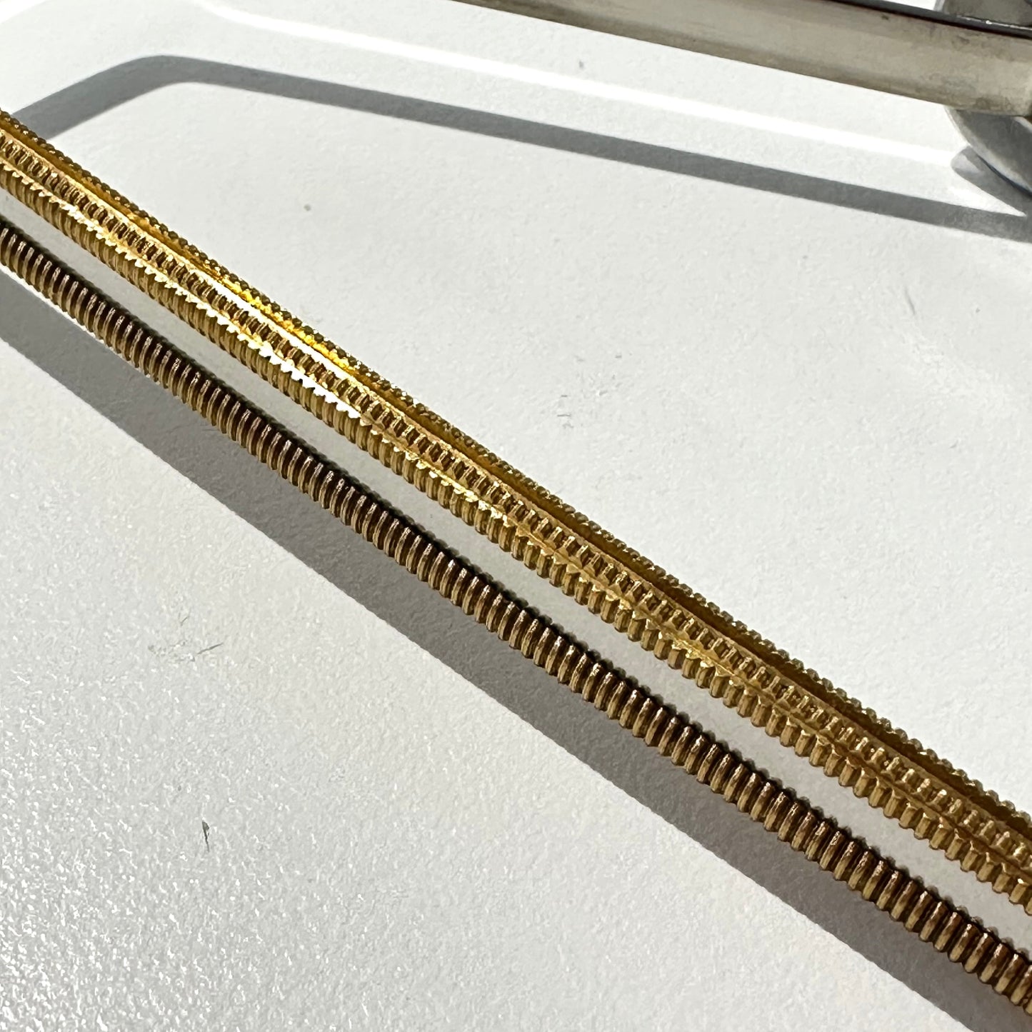 Lint remover with metallic handle with gold trim on a white surface
