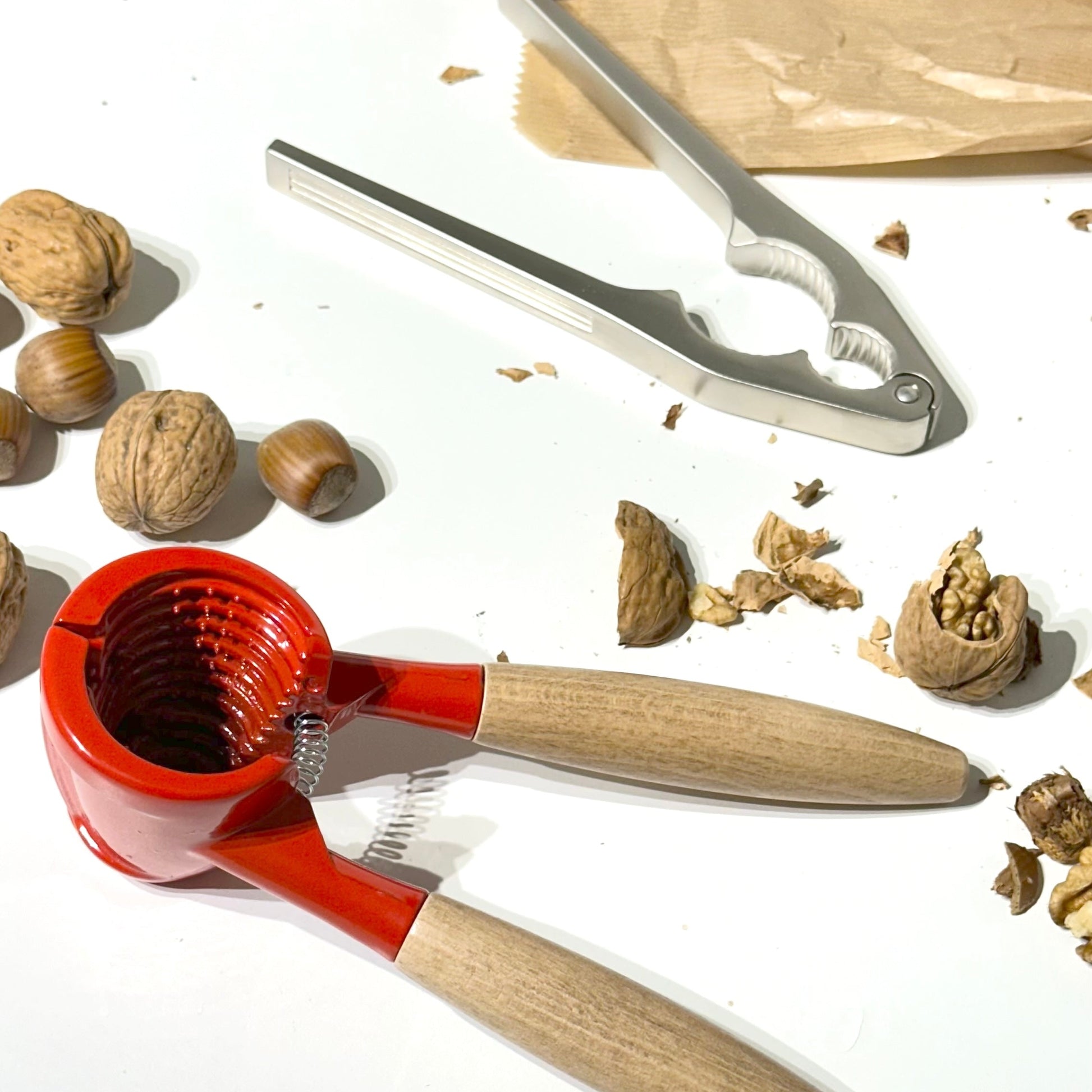 Nuts and two nutcrackers on a white surface.