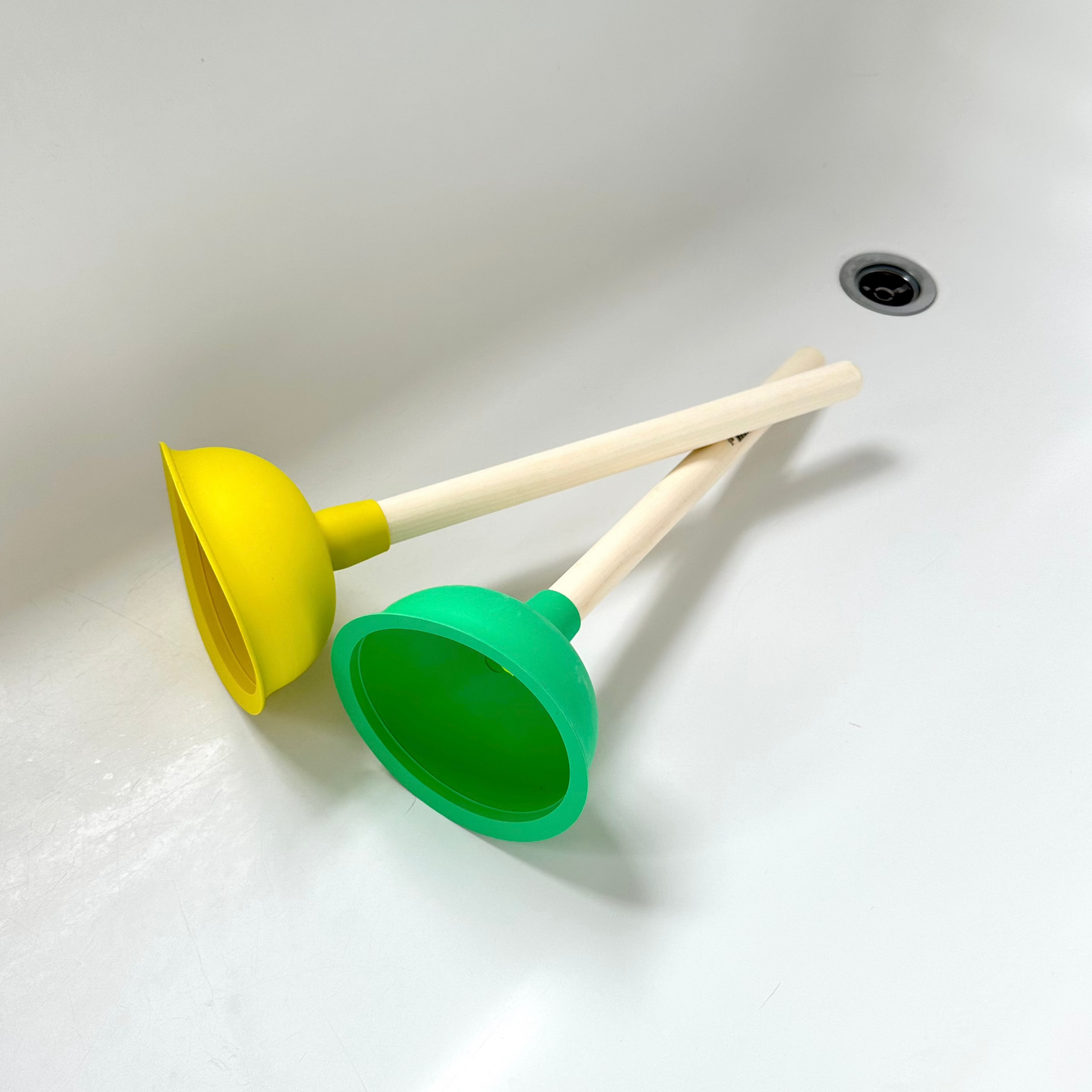 Yellow and green plungers in a bathtub