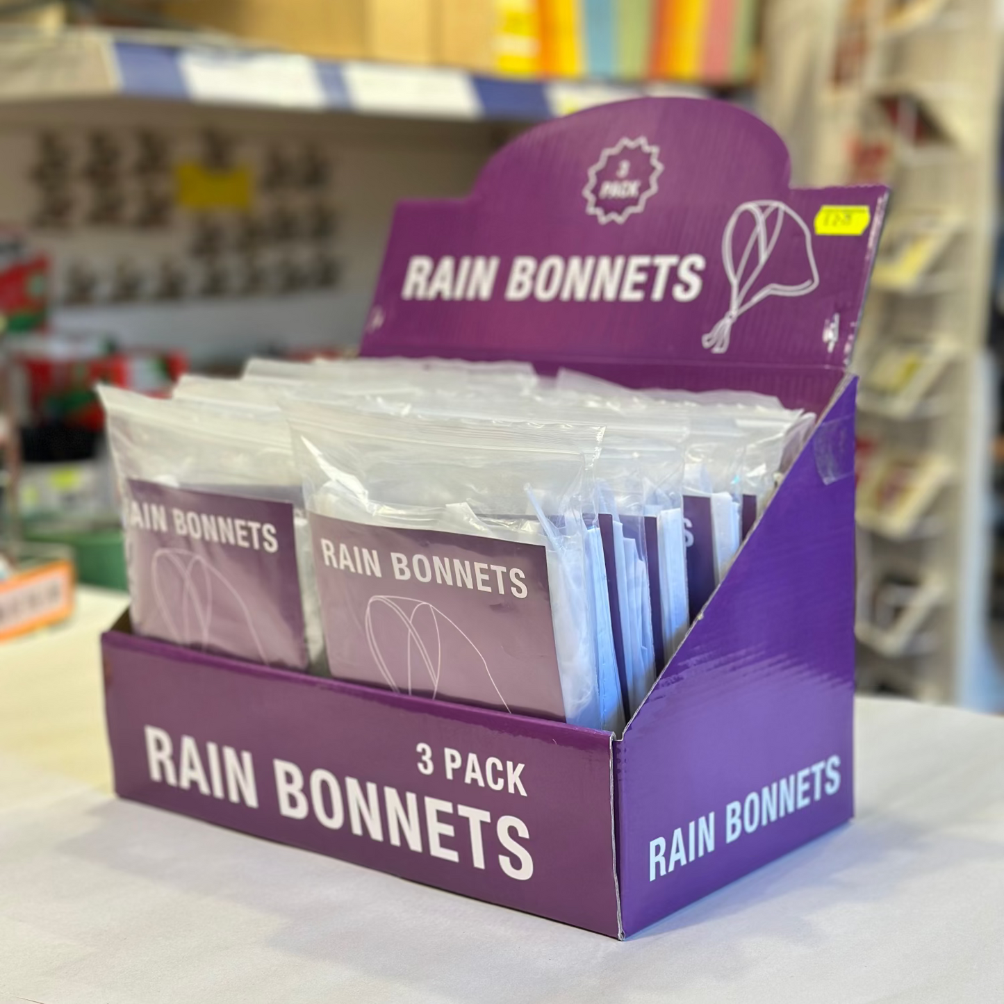 Display of Rain Bonnets packaging on a shelf in a store.