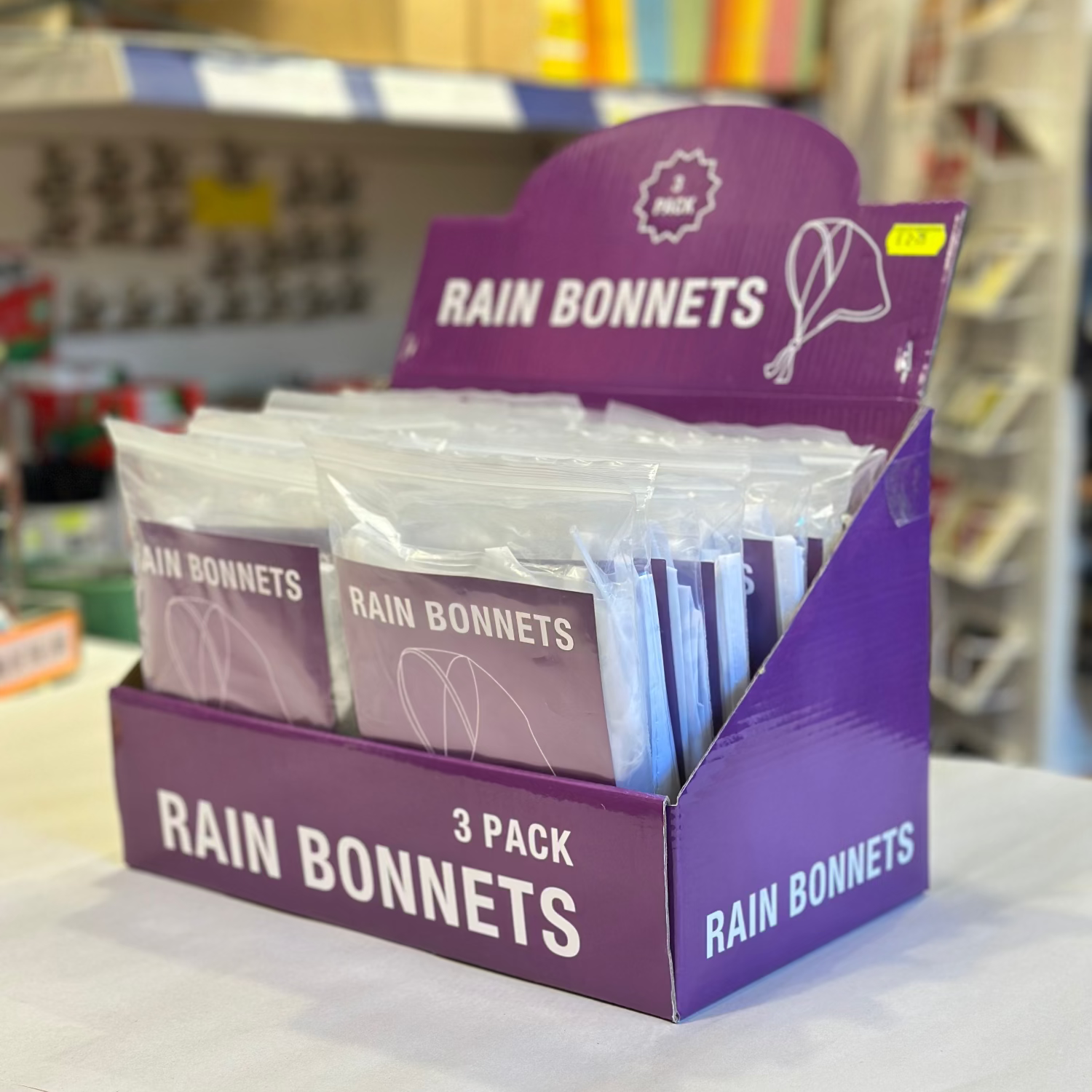 Display of Rain Bonnets packaging on a shelf in a store.