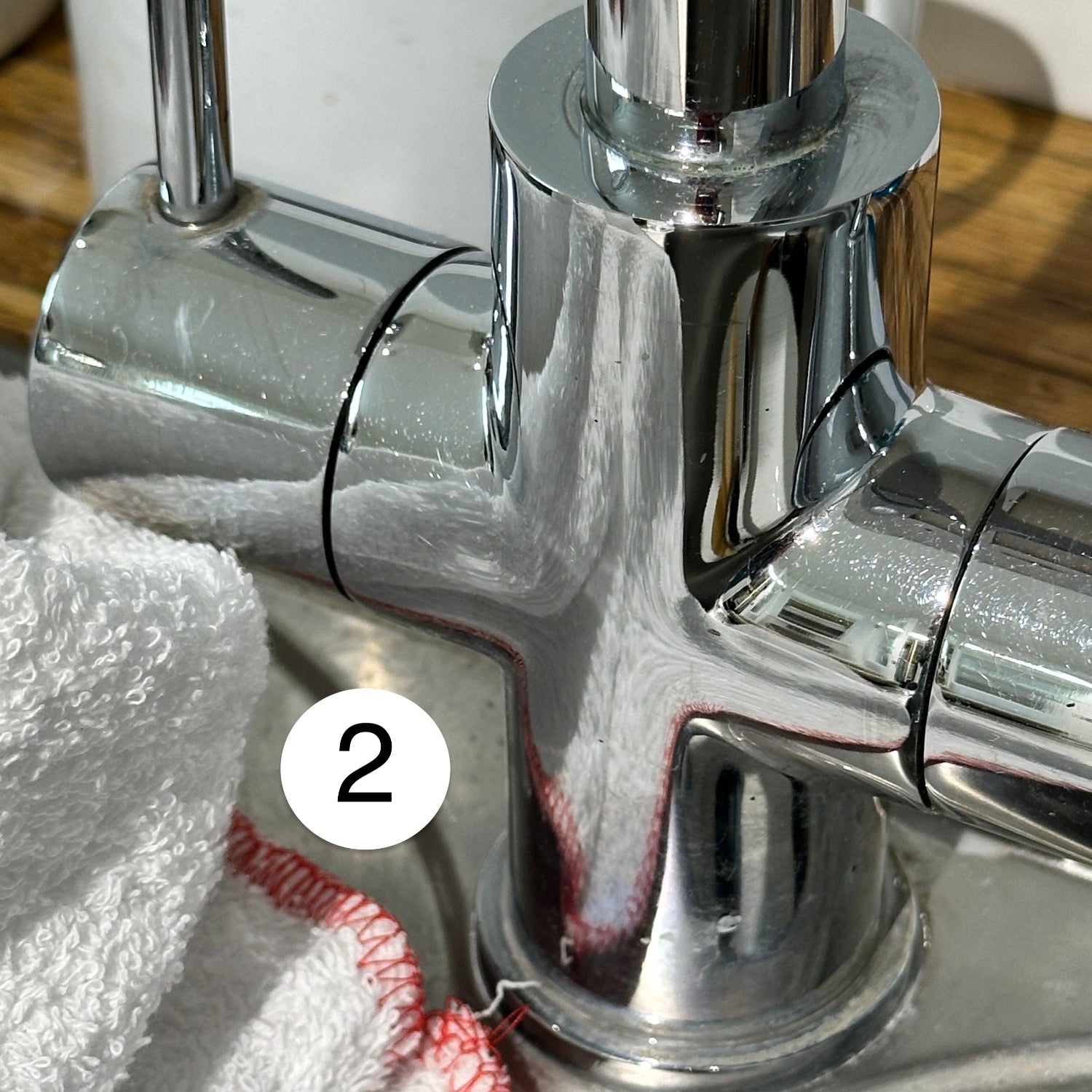 Shiny kitchen tap with terry towel cloth