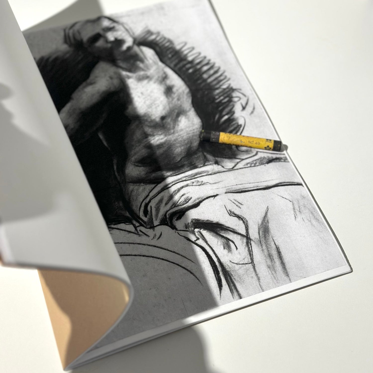 Open book with a black and white illustration of a person on a white surface