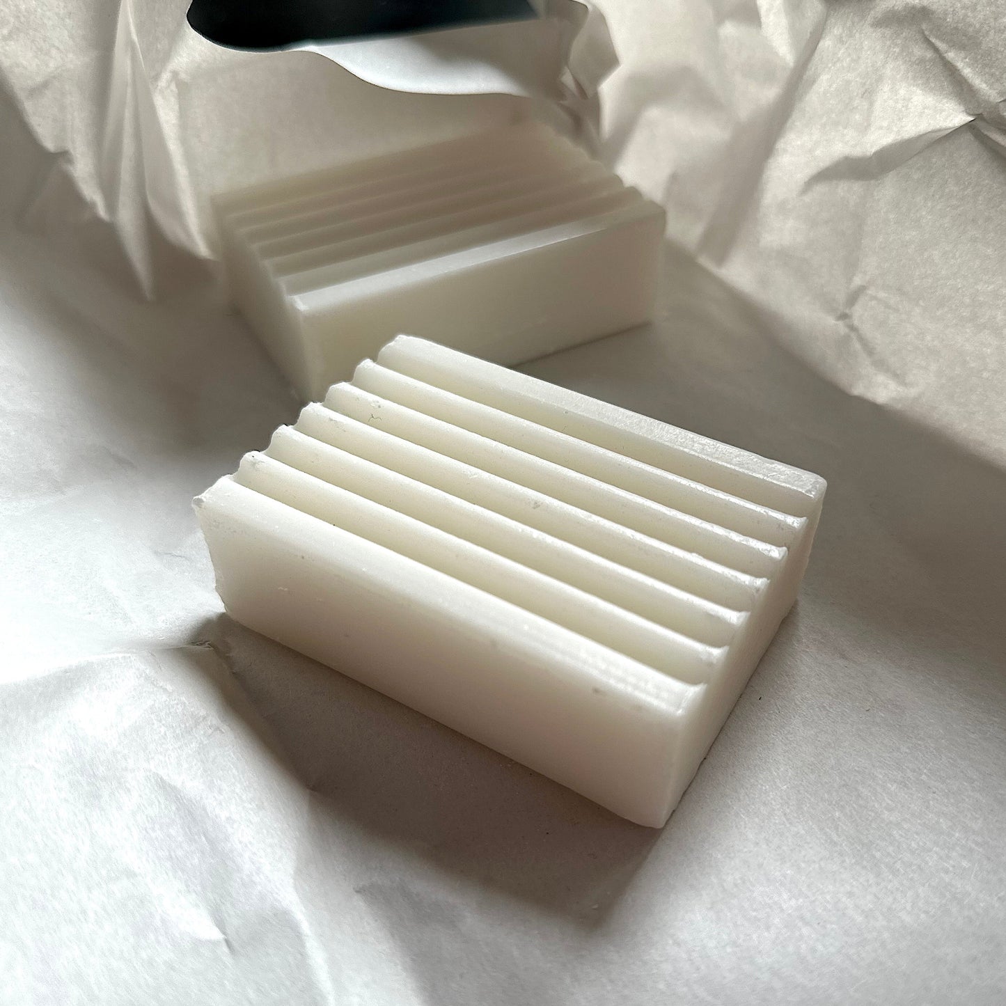 White soap bars on a white paper background