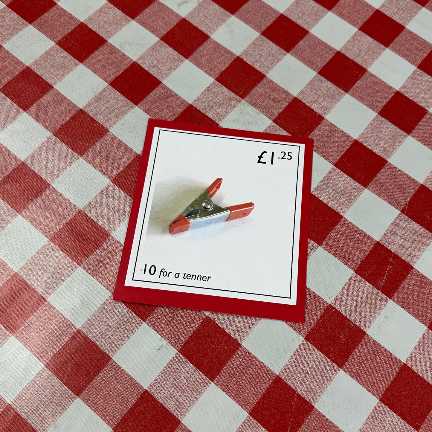 Card with a red border on a red and white checkered tablecloth