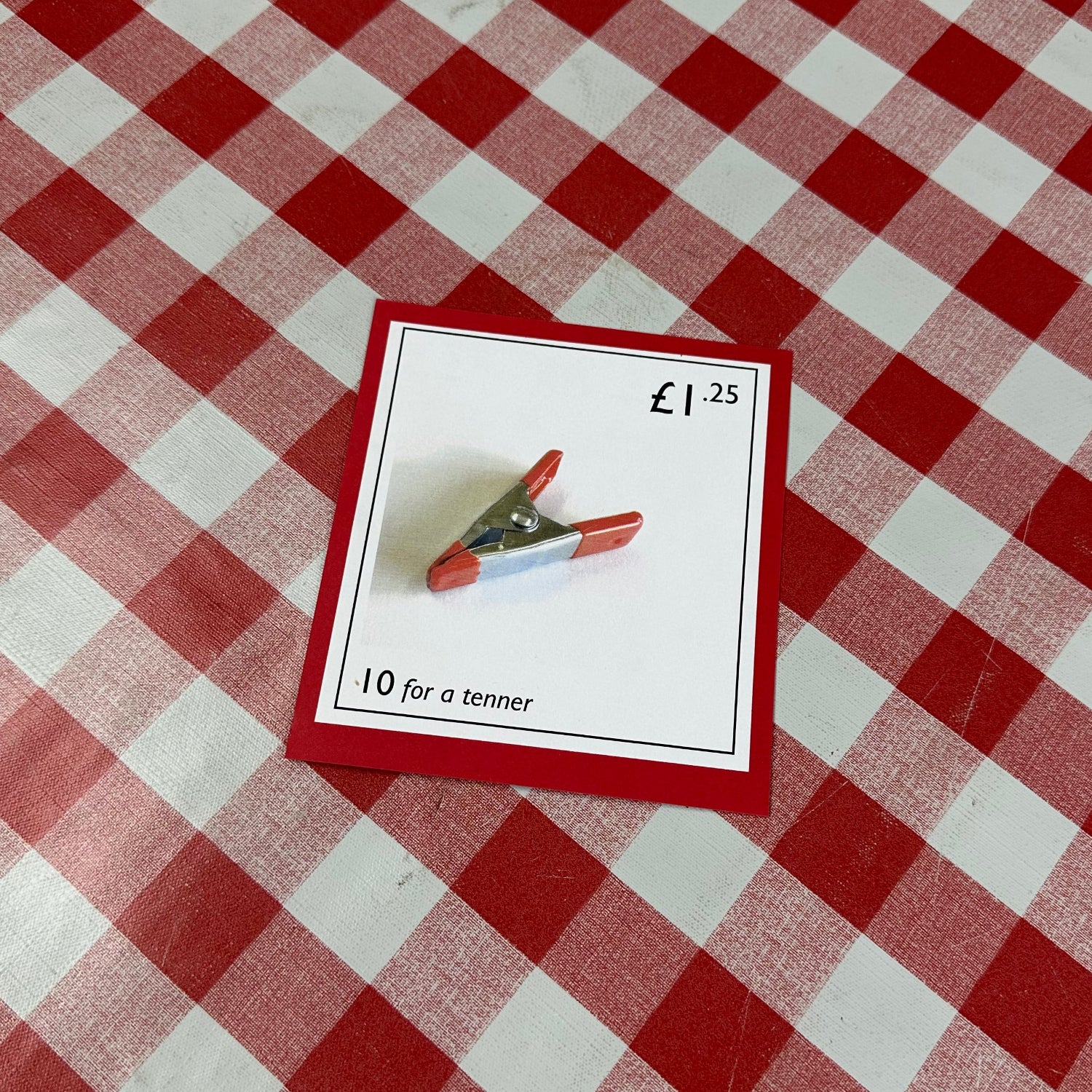 Card with a red border on a red and white checkered tablecloth