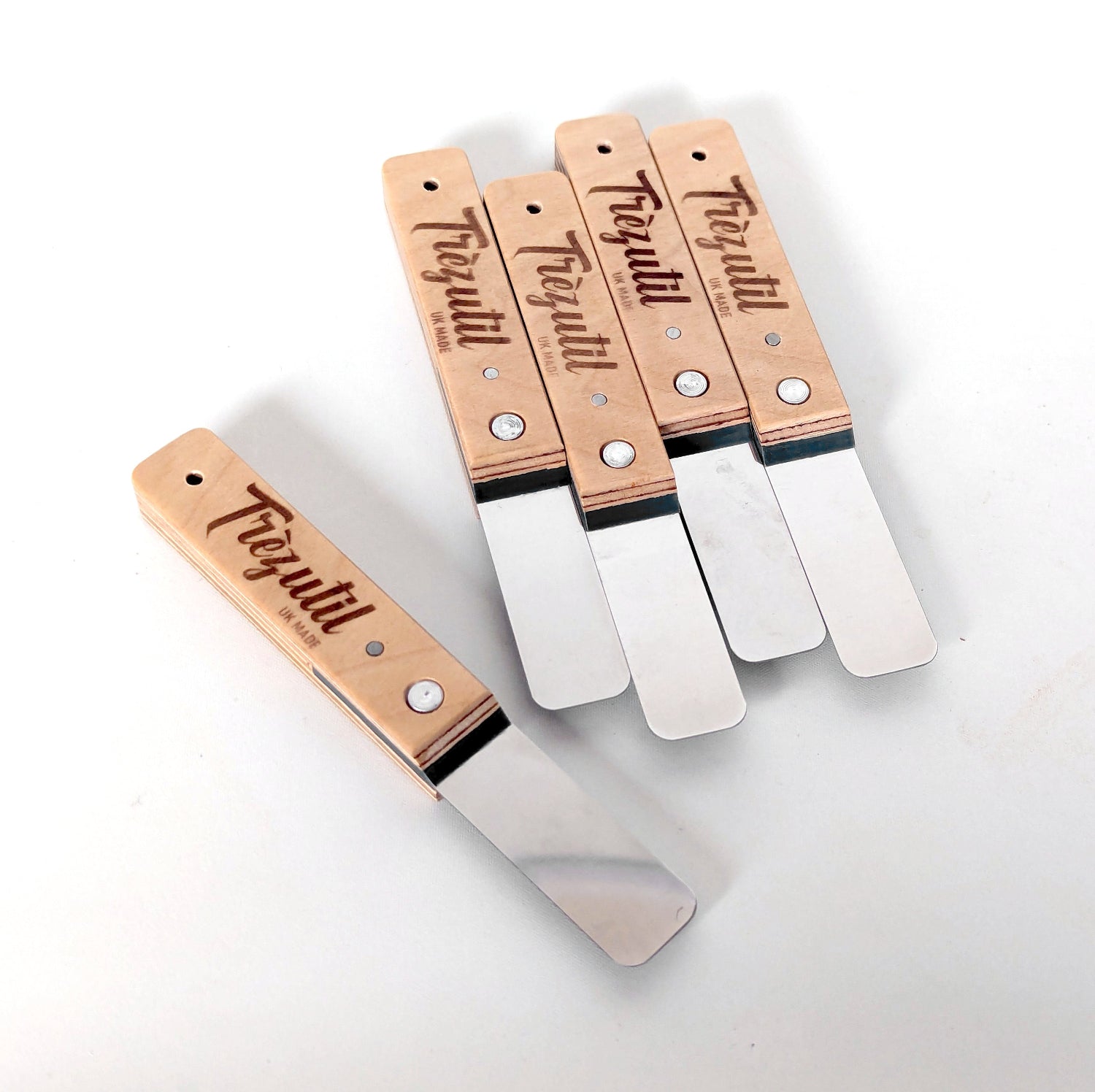 Set of four metal spatulas with wooden handles on a white background