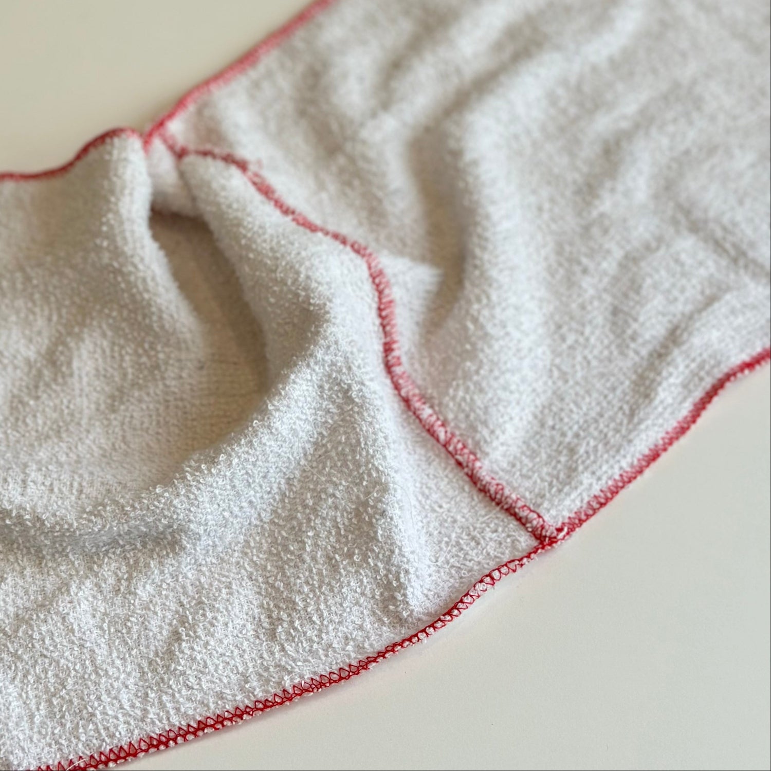 White towel with red trim on a light background