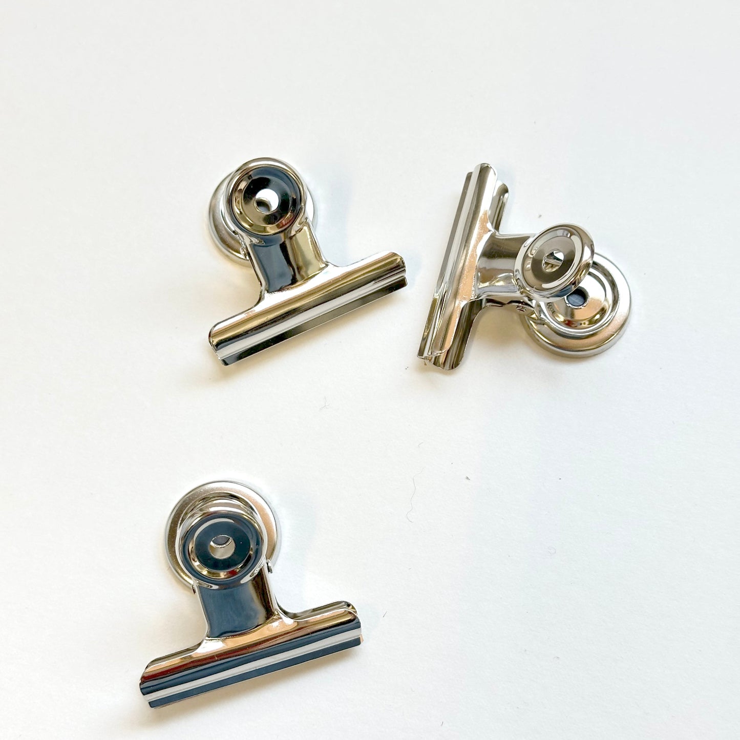 Three metallic clip-like objects on a white background