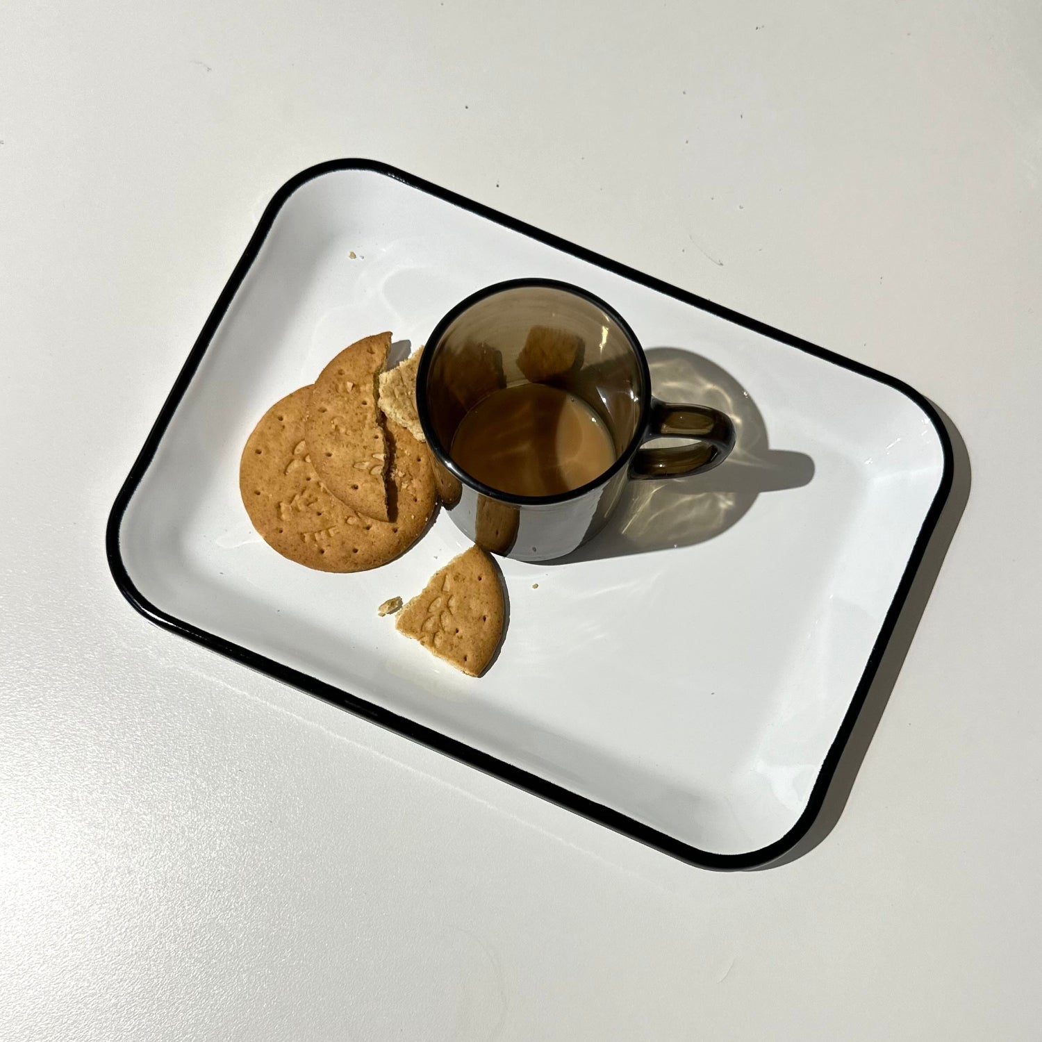 Utility Brighton enamel tray white with black rim with coffee cup and biscuits seen from above