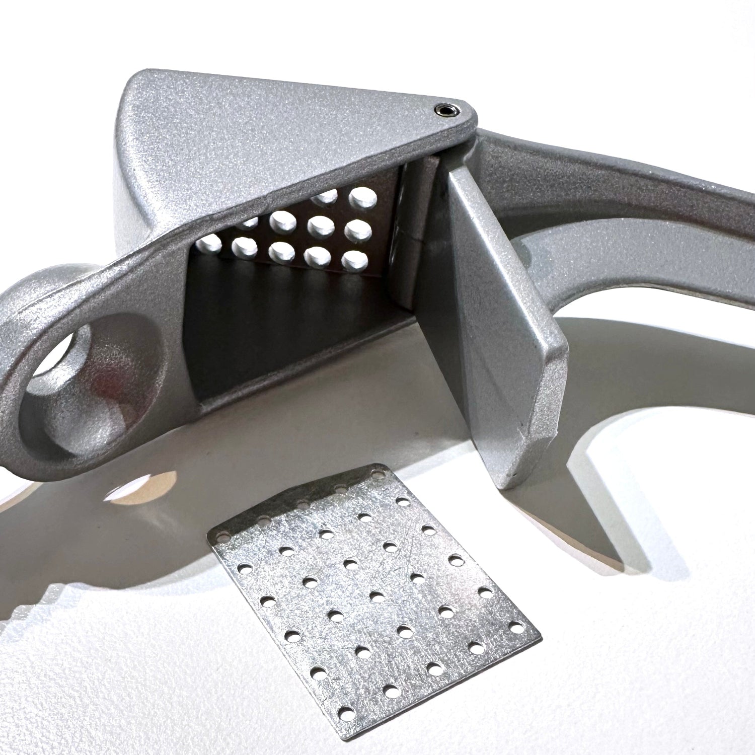 garlic press with insert for finer pressing on white background