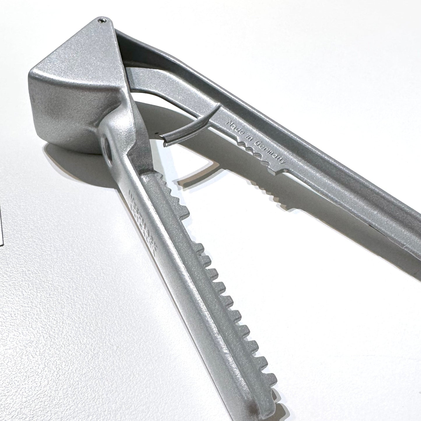 Metallic garlic press on a white background