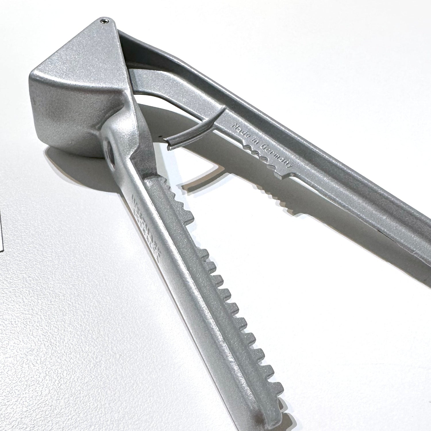 Metallic garlic press on a white background