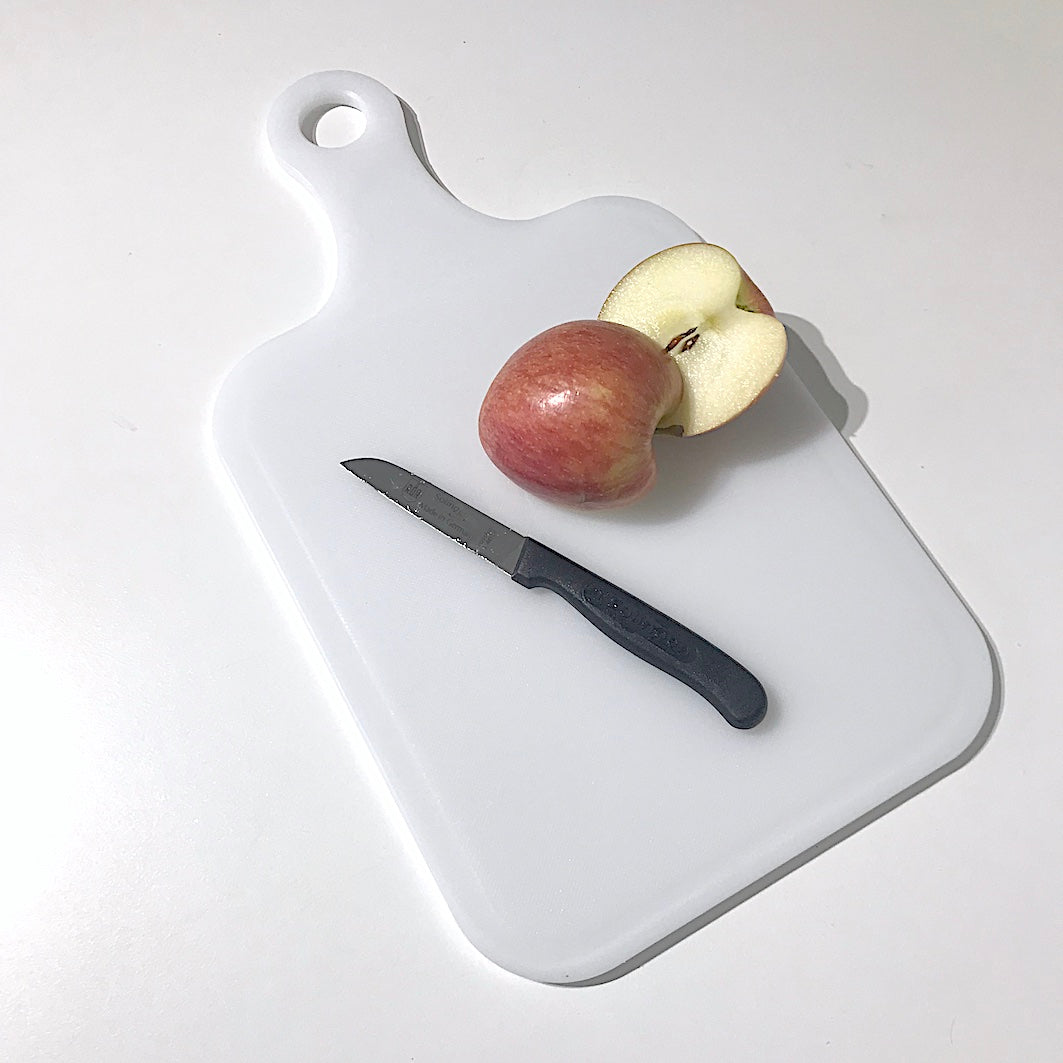 White plastic chopping board with apple
