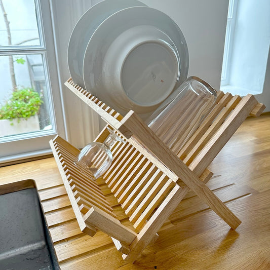 Wooden dish drainer on wooden draining board with dishes