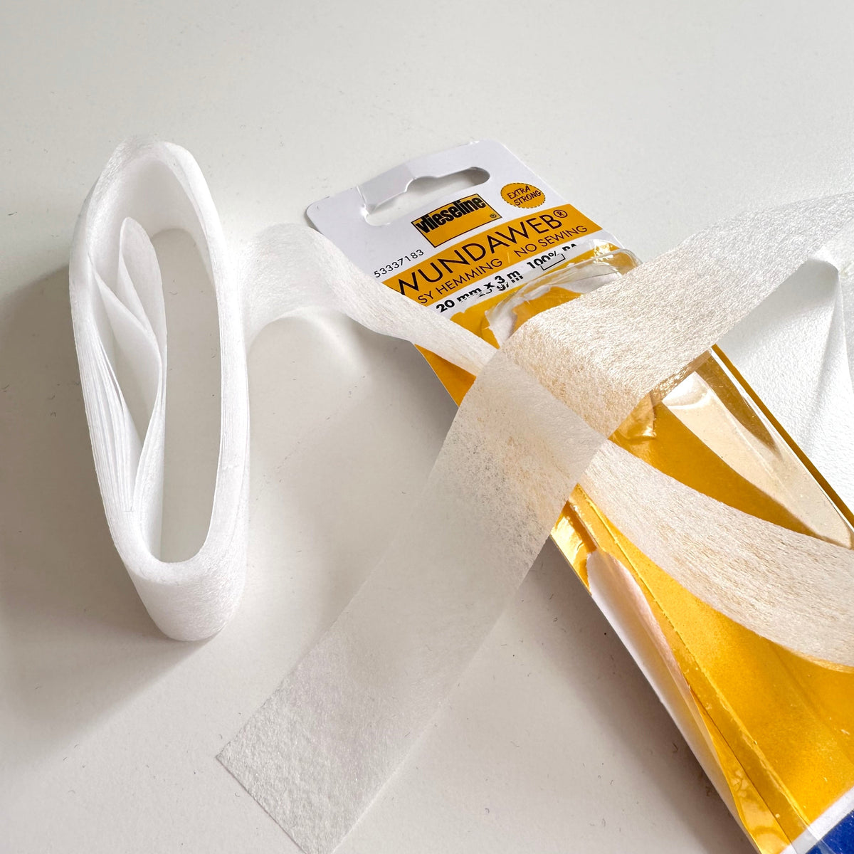 Wundaweb hemming tape detail unravelled out of package on white background