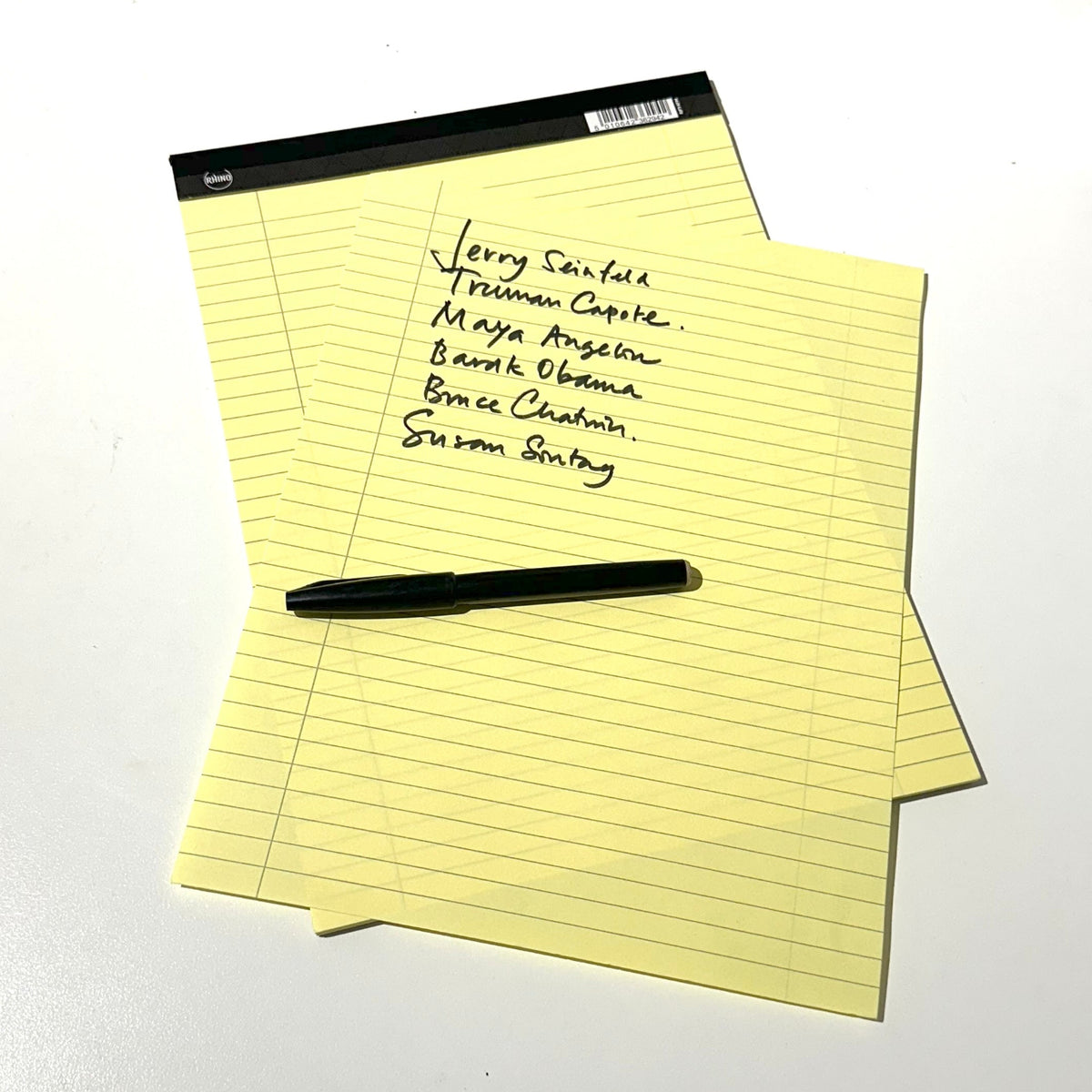 Yellow Legal Paper Script Writing Yellow legal pad with sheet torn off and black pen handwriting