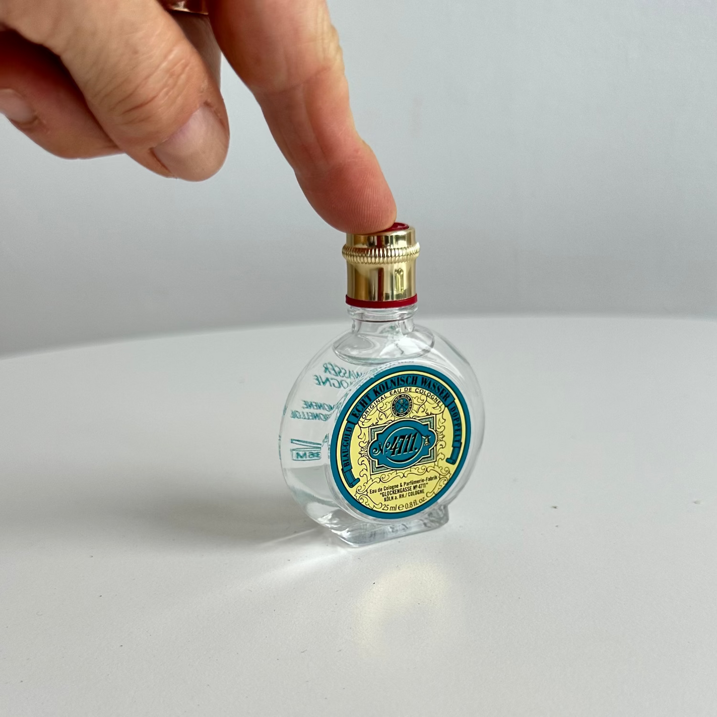 bottle of 4711 25ml  white background and hand